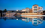 Modernes Hotel mit eleganter Fassade in ruhiger Lage – der große Infinity-Pool spiegelt das Gebäude eindrucksvoll und sorgt für eine stimmungsvolle Urlaubskulisse.