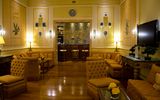 Eleganter Hotel-Loungebereich mit stilvollen Sitzgruppen, warmen Farben und klassischem Dekor – einladender Ort zum Entspannen mit gemütlicher Atmosphäre und charmanten Details.