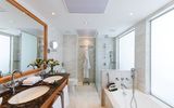 Helles, elegantes Bad mit Doppelwaschbecken, moderner Dusche und einladender Badewanne für entspannte Momente.