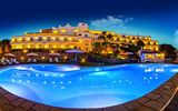 großer beleuchteter Außenpool am Abend im Hotel Luci di la Muntagna auf Sardinien in Italien