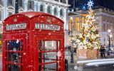 Rote Telefonzelle in London vor einem beleuchtetem Weihnachtsbau