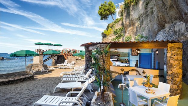 Sandstrand mit Liegen und Bar am Hotel La Madonnina auf Ischia, Italien
