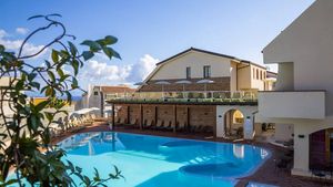 Moderner Hotelpool mit großzügiger Sonnenterrasse, gemütlichen Liegen und mediterranem Flair in zentraler Lage.